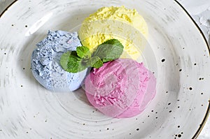 Set of ice cream scoops of different colors and flavours with berries, nuts and fruits