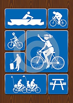 Set icons of rowing boat, family ride, bicycle, roasting area. Icons in blue color on wooden background.