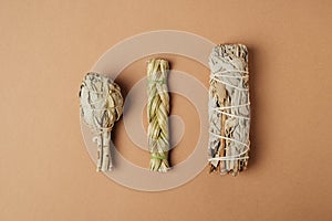 Set of incense for fumigation of premises. Branches of white sage and sweetgrass tied in a bunch on a nude background.