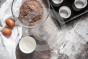 Set of ingredients for cupcakes. Flour, eggs, oil on a gray wooden old table. Rustic style, culinary copy-space