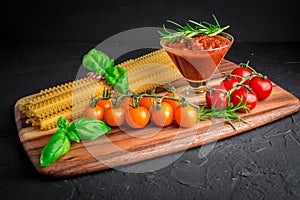 Set of ingredients for vegetarian pasta bolognes cherry tomatoes basil, pasta onions garlic tomatoes sauce