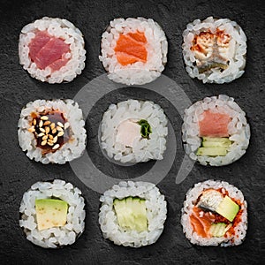 Set Japanese rolls assortment, hosomaki close-up are served on a stone board. Vertical top view from above