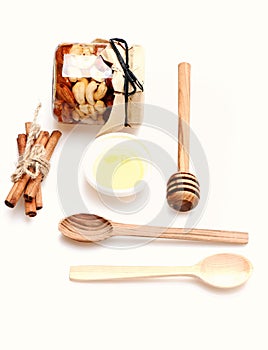 Set of jar with nuts, honey, wooden cutlery and cinnamon.