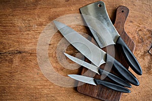 Set of kitchen knifes on wooden cutting board