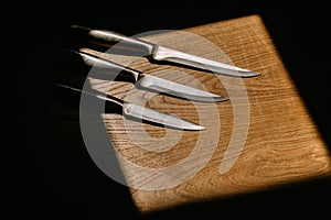 set of kitchen knives on a wooden cutting board