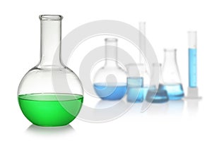 Set of laboratory glassware with colorful liquids on background