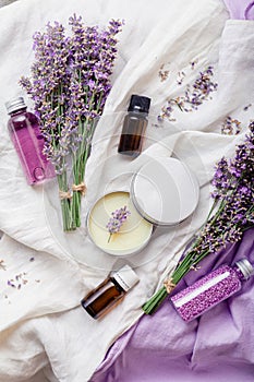 Set lavender skincare cosmetics products. Natural spa beauty products fresh lavender flowers on white fabric. Lavender essential