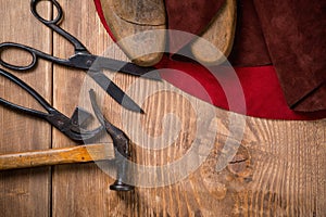 Set of leather craft tools on wooden background. Workplace for shoemaker.