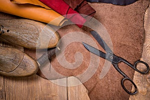 Set of leather craft tools on wooden background. Workplace for shoemaker.