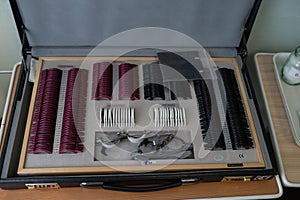 Set of lenses for checking vision in office of an ophthalmologist. Ophthalmologist`s suitcase. High angle view. Close up