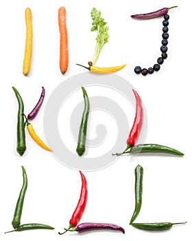 set of letter j k i l made from green orange red purple yellow chili pepper, blueberry and celery plant stick