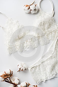 Set of lingerie, beige with black white ribbons. On white background on white background decorated with cotton flowers