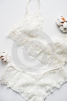 Set of lingerie, beige with black white ribbons. On white background on white background decorated with cotton flowers