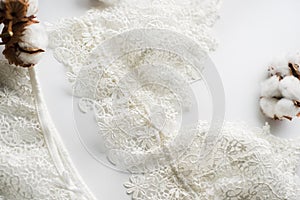 Set of lingerie, beige with black white ribbons. On white background on white background decorated with cotton flowers