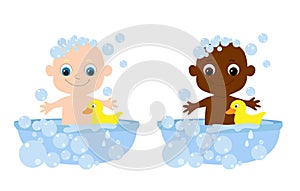 Set little cute baby bathes in a bathtub with soap bubbles and a yellow rubber duck. The child smiles happily.