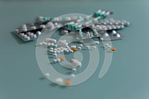 Set of loose pills and complete tablets on green glass table