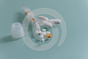 Set of loose pills and complete tablets on green glass table