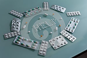 Set of loose pills and complete tablets on green glass table