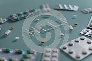 Set of loose pills and complete tablets on green glass table