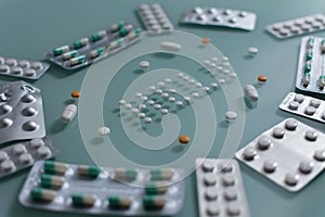 Set of loose pills and complete tablets on green glass table