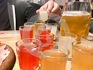 A set of lots of delicious yellow orange red glasses, shots with strong alcohol, vodka, brandy, brandy, beer on wooden