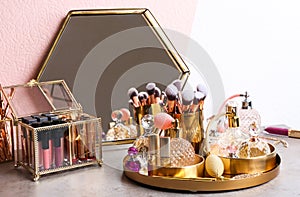 Set of luxury makeup products and perfumes on table