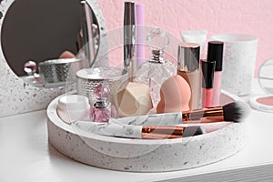 Set of luxury makeup products and perfumes on table
