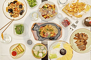 Set of mainly Asian and Chinese dishes, udon noodles with vegetables and shrimp, Vietnamese rolls, chicken with shiitake mushrooms