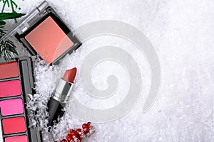 Set of make-up cosmetic products on a winter background made of snow. Concept of a gift for woman in the Christmas season.