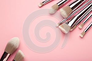 Set of makeup brushes on pink background. Top view. Space for text