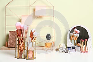 Set of makeup products and brushes on table