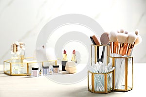 Set of makeup products and brushes on table