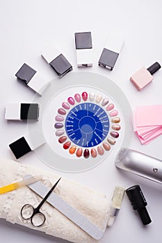 Set for manicure with gell polish  bottles, LED lamp and accessoires on white background. flat lay photo