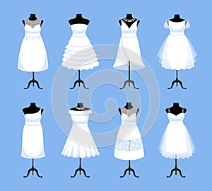 Set of mannequins in different white wedding dresses.