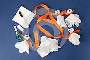 Set of materials for Halloween toys ghost from white paper napkin. Creative DIY for kids on classic blue background. Home decor