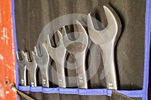 A set of metal open-end wrenches in the workshop