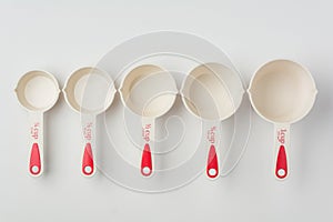 Set of Measuring Cups Lined on White Background Top View