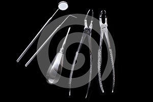 Set of metal medical equipment tools for teeth dental care isolated on black