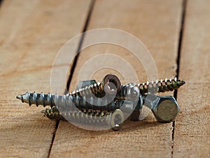 Set of metal screws on a wooden Board. Close-up of metal screws and bolts for wood on a wooden surface with space for text. Tools