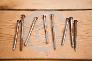 Set of metalware, rusty nails on the wooden background photo