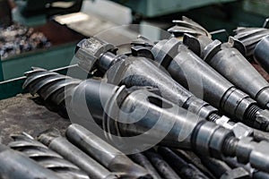 A set of milling cutters on a rack near a lathe. Metalworking cutting mills for CNC machines. Industrial processing of metal