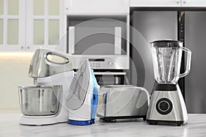 Set of modern home appliances on marble table in kitchen