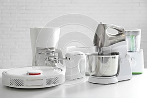 Set of modern home appliances on table