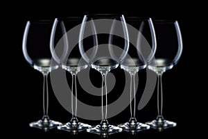 Set of mpty glasses for red wine in a row isolated on black background.