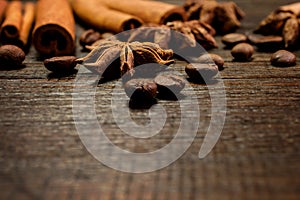 Set for mulled wine: anise stars, cinnamon sticks, coffee grains on wooden vintage background. Template for design. Macro