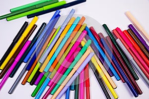 A set of multi-colored felt-tip pens in a row, rainbow on a light white banner background. Drawing markers, pencils, ink, artist