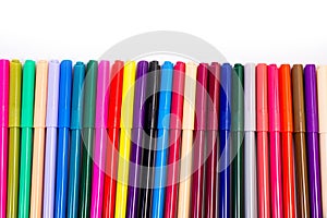 A set of multi-colored felt-tip pens in a row, rainbow on a light white banner background. Drawing markers, pencils, ink, artist