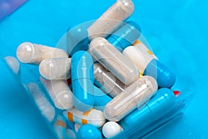 Set of multi-colored tablets and capsules on a blue background