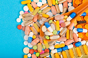 Set of multi-colored tablets and capsules on a blue background