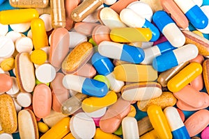 Set of multi-colored tablets and capsules on a blue background